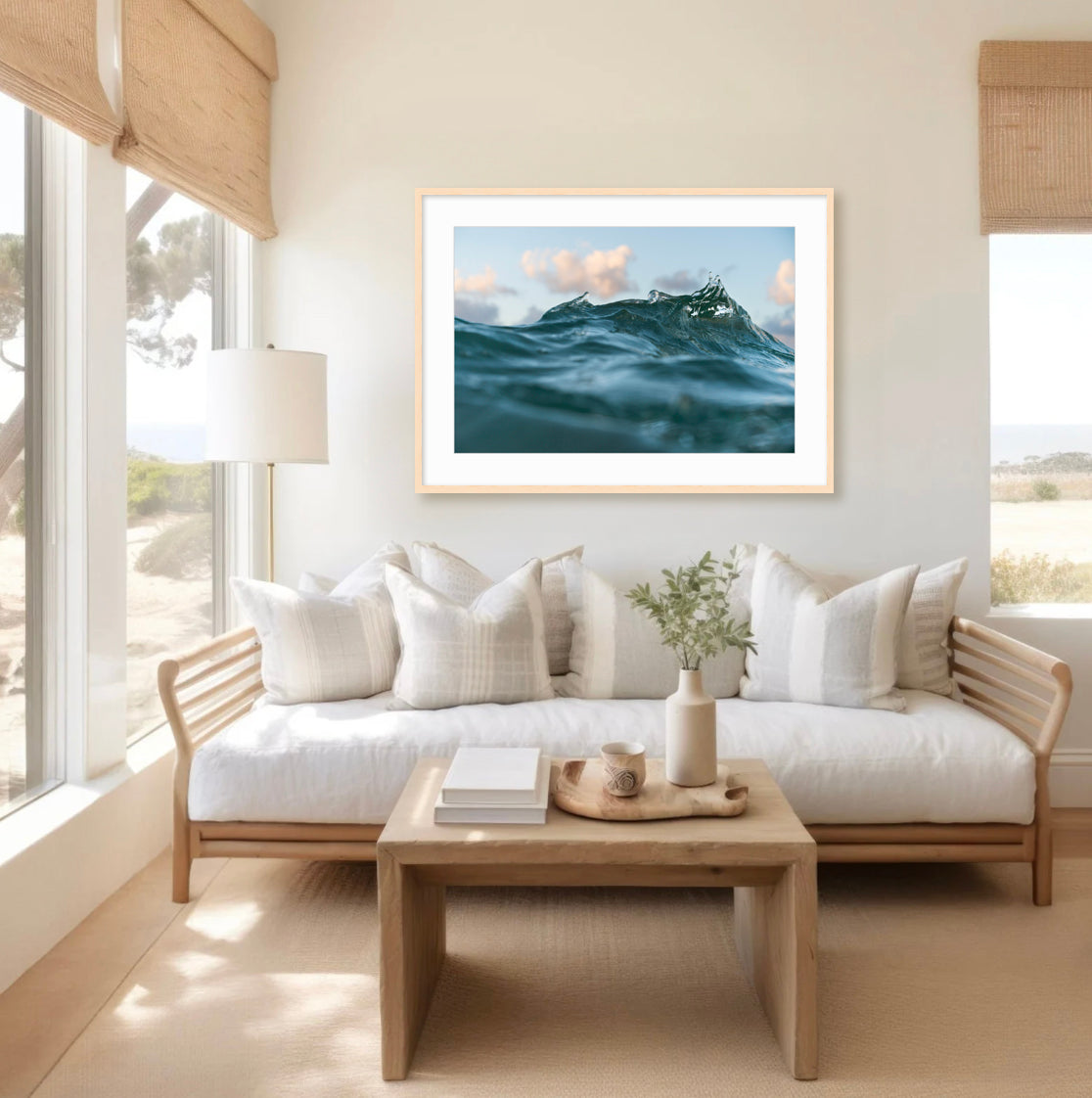 Living room with a white sofa, wooden coffee table, and framed artwork of ocean waves.